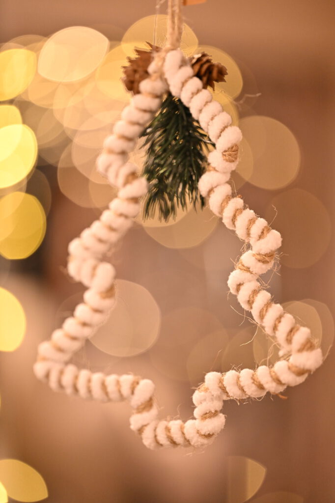 Weißer Baum-Anhänger vor goldenen Lichtern